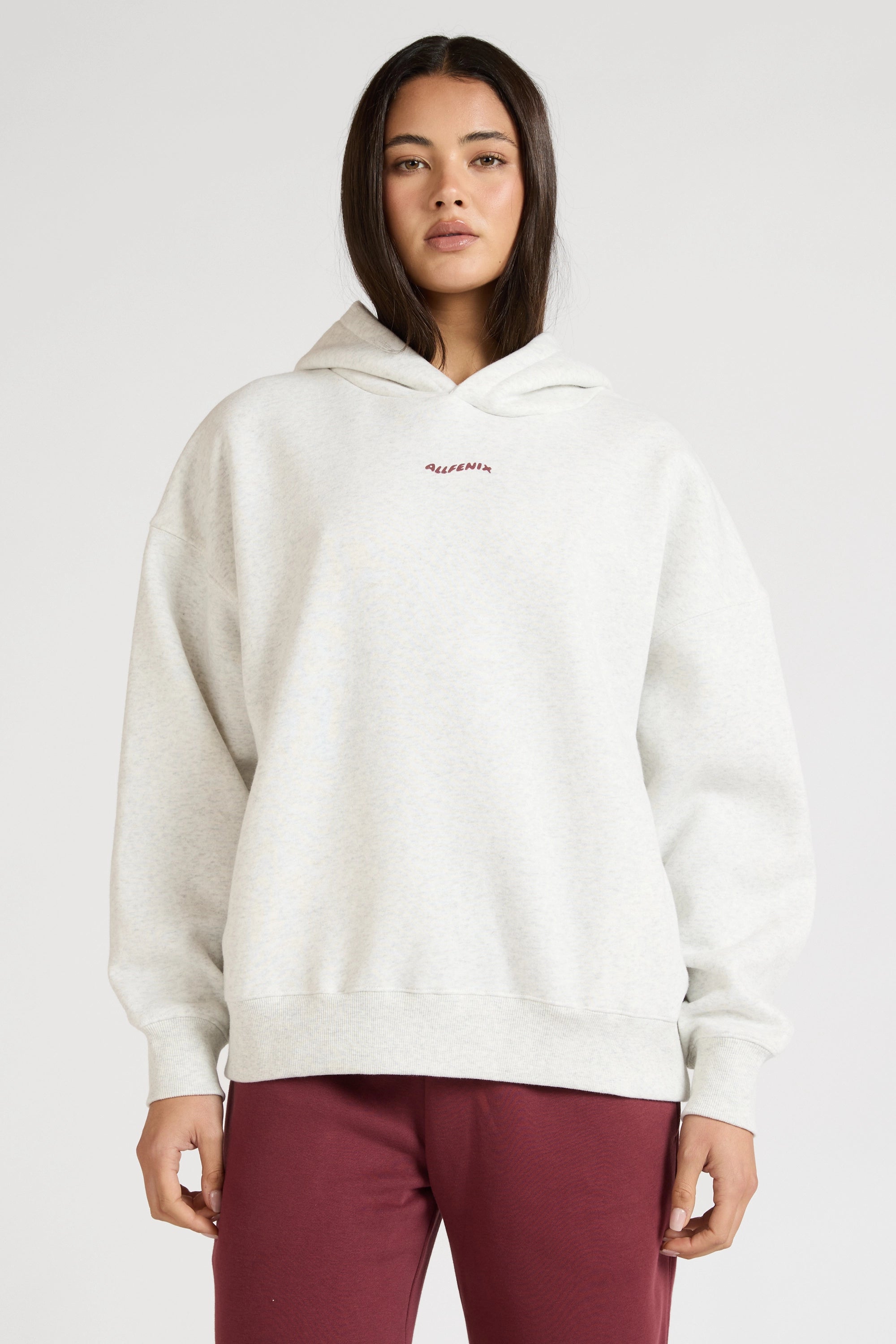 Woman wearing a white hoodie with text on a plain background