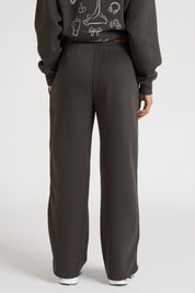 Woman wearing dark grey sweatpants and a matching hoodie on a white background