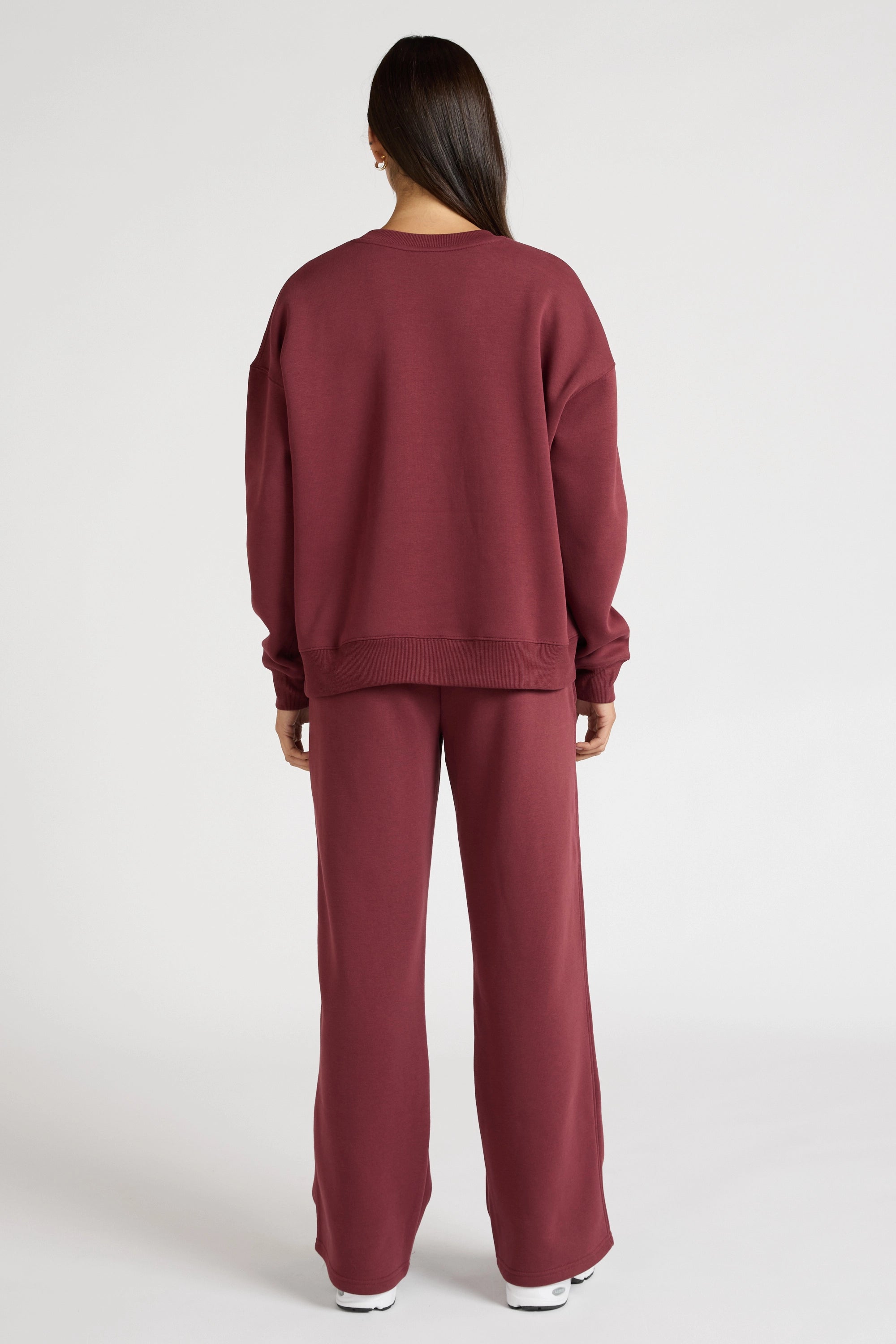 Woman wearing a maroon sweatshirt with 'All Fenix Pilates Series' text on a white background