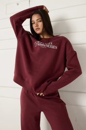 Woman wearing a maroon sweatshirt with 'All Fenix Pilates Series' text on a white background