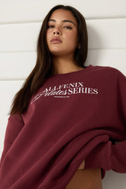 Woman wearing a maroon sweatshirt with 'All Fenix Pilates Series' text on a white background