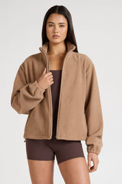 Woman wearing a brown fleece jacket on a white background